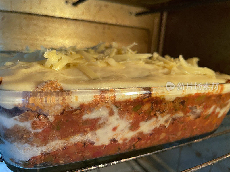 近距离图像自制千层面/千层面烹饪在热烤箱与奶酪酱层，意大利面和肉酱肉糜，重点在前景